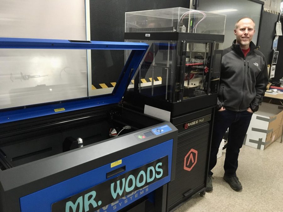 Mr. Woods is standing next to one of his various laser cutters and 3D printers that he has in his classroom. Photo Courtesy of: Jasmine Castro