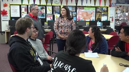 The Higher Education Center Coordinator, Mrs. Huezo, stands in front of a group of Segerstrom students. 