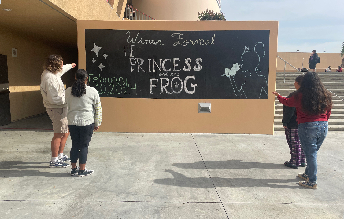 Segerstrom+students+discuss+the+Winter+Formal+theme%2C+The+Princess+and+the+Frog%2C+as+they+observe+the+new+decorations+near+the+ASB+window.