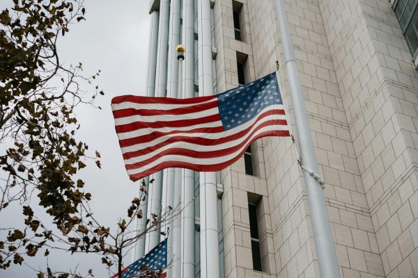 Image showcasing the United States flag hanging on a building.  It symbolizes the political aspect of the US government shutdown.