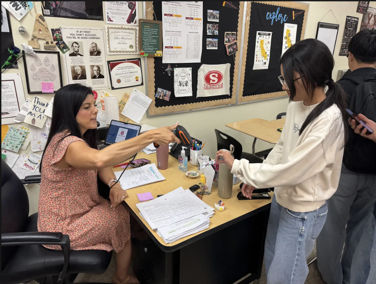Depicted is Mrs. Altamirano signing students in for tutorial. Teachers must turn down students who aren't signed up for their tutorial, so it's paramount to sign up and go to the correct classroom.
